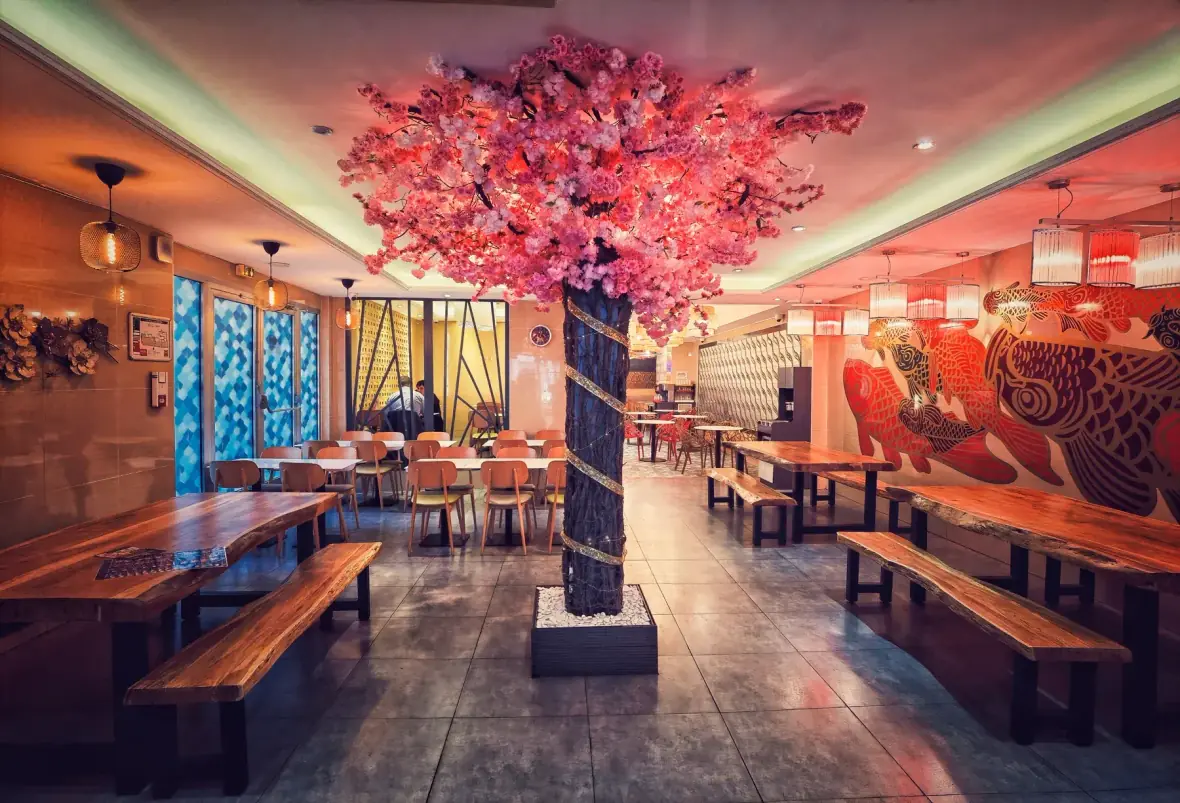 La salle de Yummy, ses tables en bois et son cerisier rose au centre